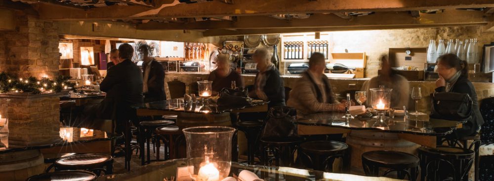 Een aantal mensen die genieten van een glas wijn in de wijnkelder van Huis Colvenier Antwerpen
