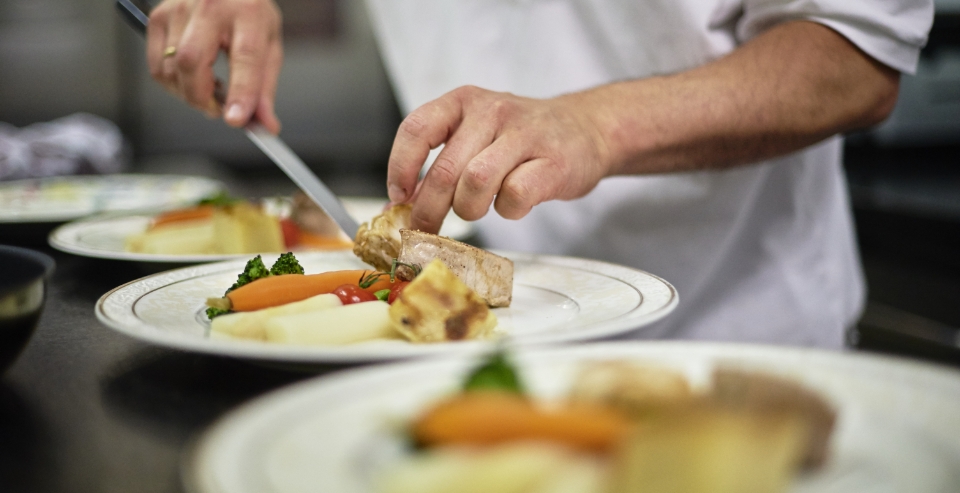 Chef Patrick die een bord dresseert in restaurant Huis De Colvenier Antwerpen
